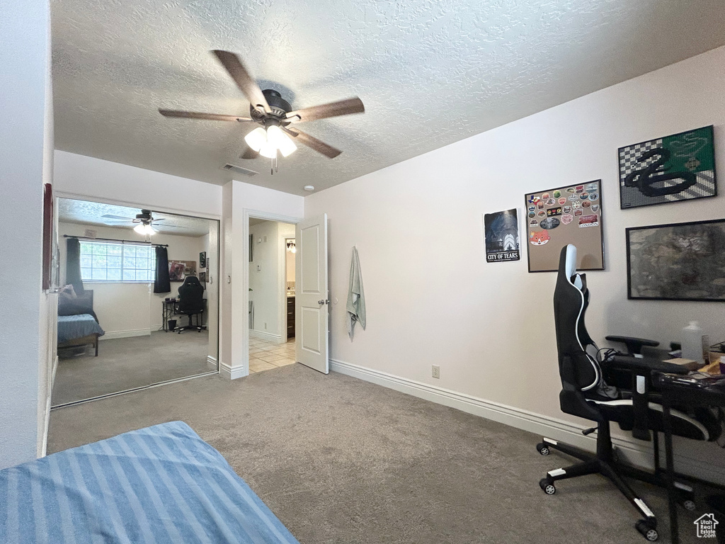 Carpeted office with ceiling fan, a textured ceiling, and baseboards