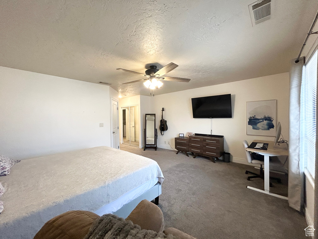 Bedroom featuring a textured ceiling, carpet, a ceiling fan, and baseboards
