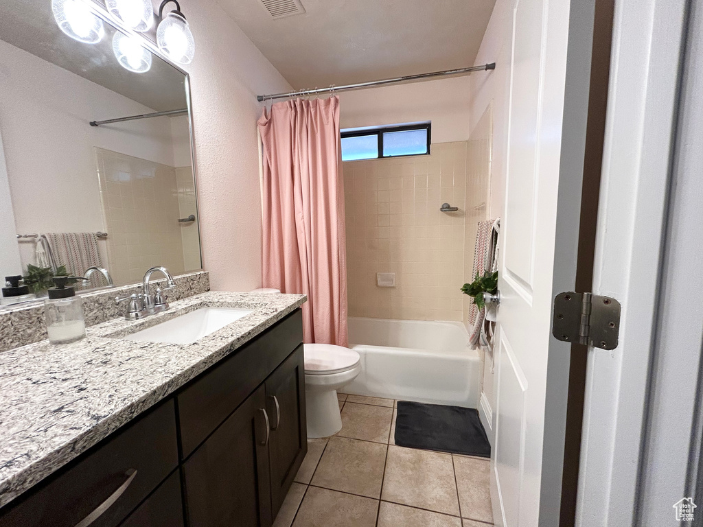 Bathroom with toilet, vanity, shower / tub combo with curtain, and tile patterned floors
