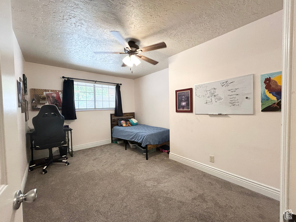 Bedroom with carpet, a textured ceiling, baseboards, ceiling fan, and an office area
