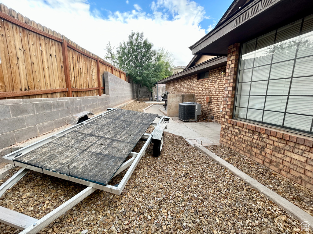 Exterior view of brick siding, a fenced backyard, and central AC unit