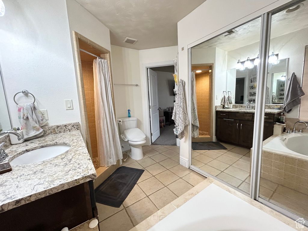 Full bathroom with vanity, a garden tub, a shower with curtain, tile patterned floors, and toilet