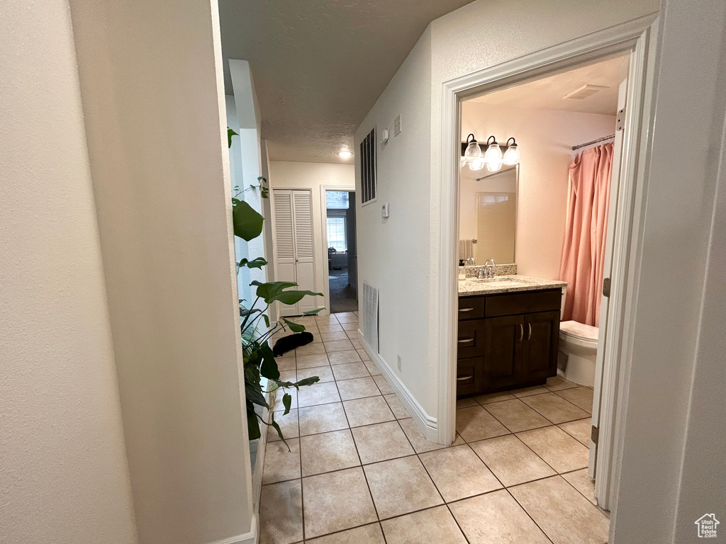 Full bathroom featuring tile patterned floors, vanity, toilet, and a shower with curtain