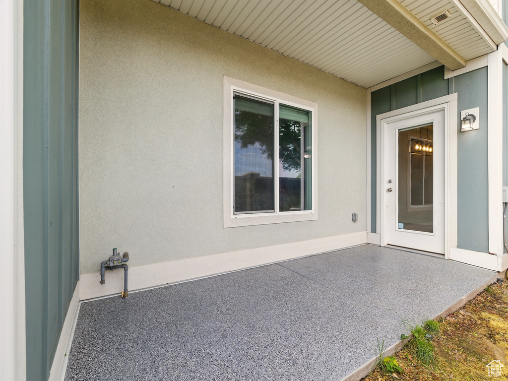 View of exterior entry featuring a patio area and stucco siding