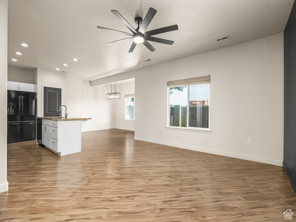 Unfurnished living room featuring light wood-style flooring, recessed lighting, a ceiling fan, and baseboards