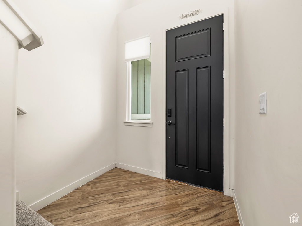 Foyer with light wood finished floors and baseboards