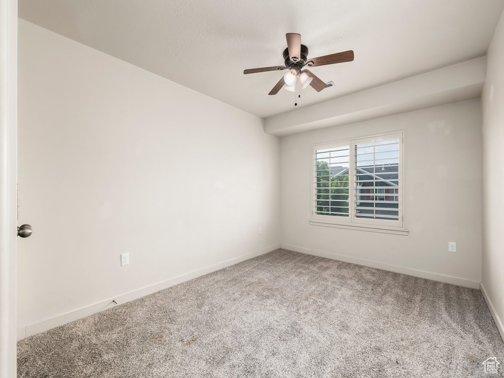 Spare room with carpet floors, ceiling fan, and baseboards
