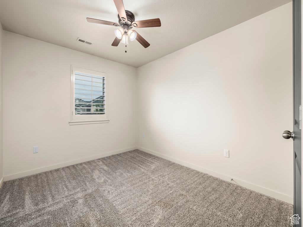 Unfurnished room featuring carpet flooring, baseboards, and ceiling fan