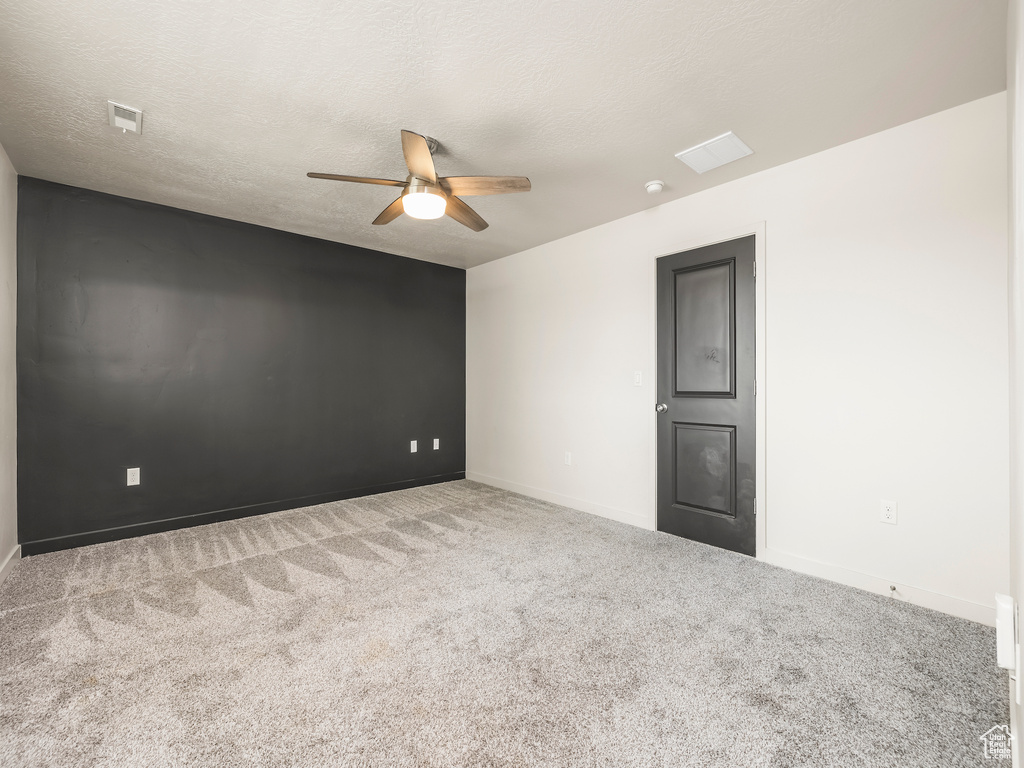 Carpeted empty room with ceiling fan, baseboards, and a smoke detector