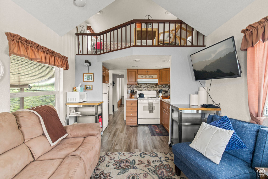 Living area with wood finished floors and high vaulted ceiling