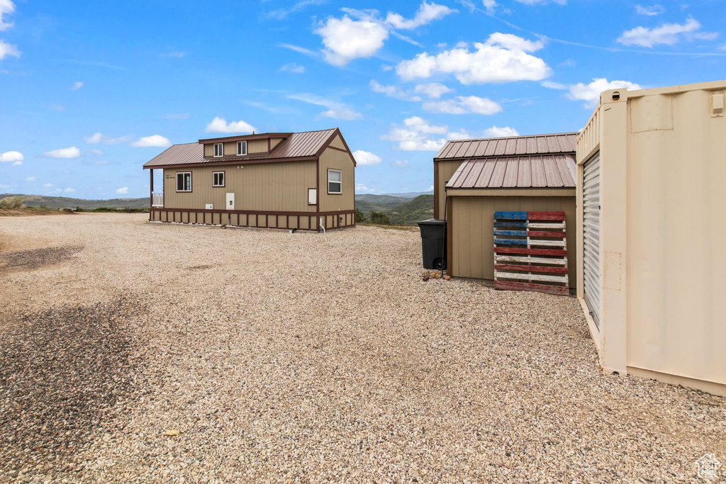 View of property exterior featuring metal roof and an outdoor structure