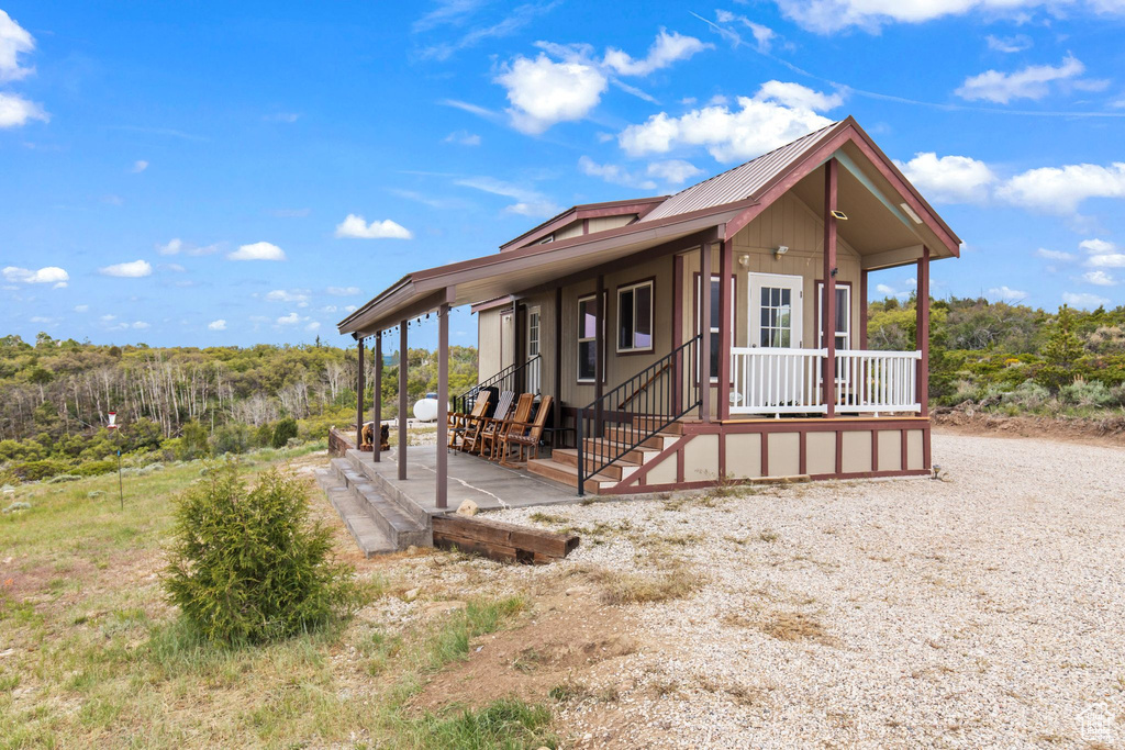 View of front of house featuring metal roof and a patio area