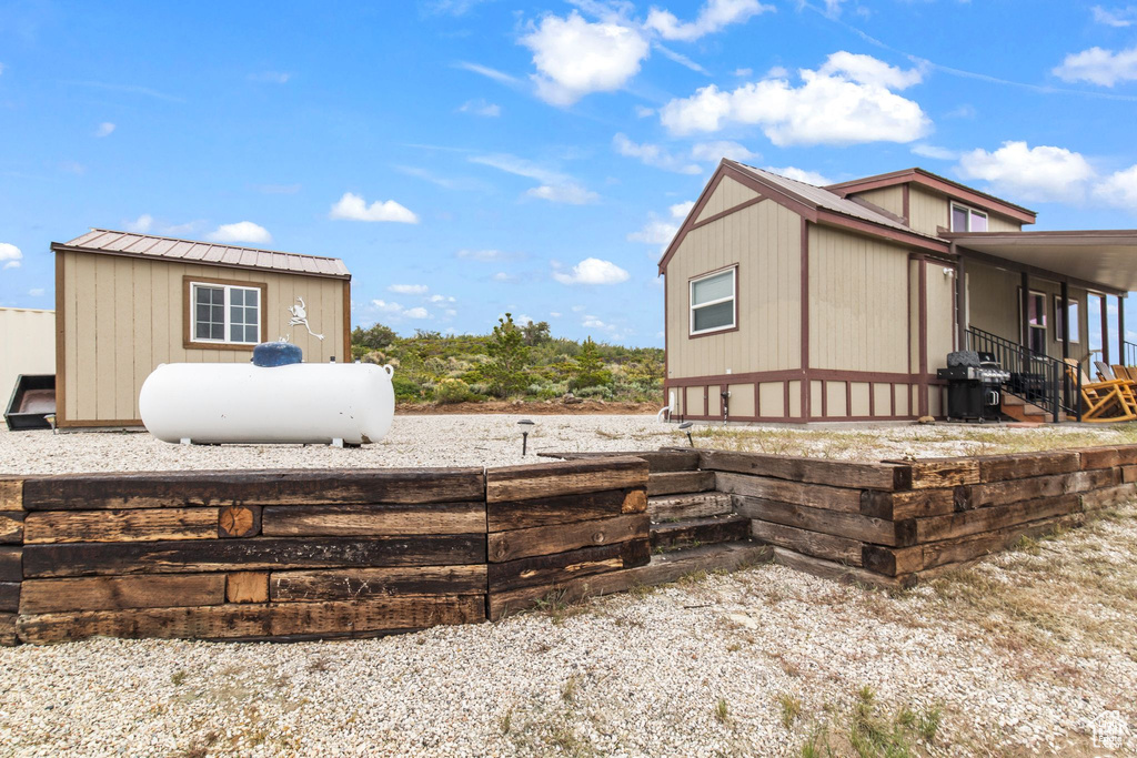 View of side of home with metal roof and an outdoor structure