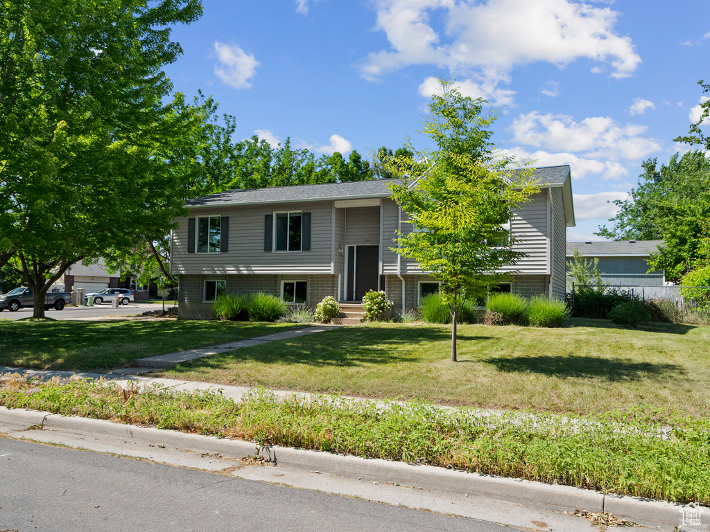 Bi-level home with a front lawn and entry steps