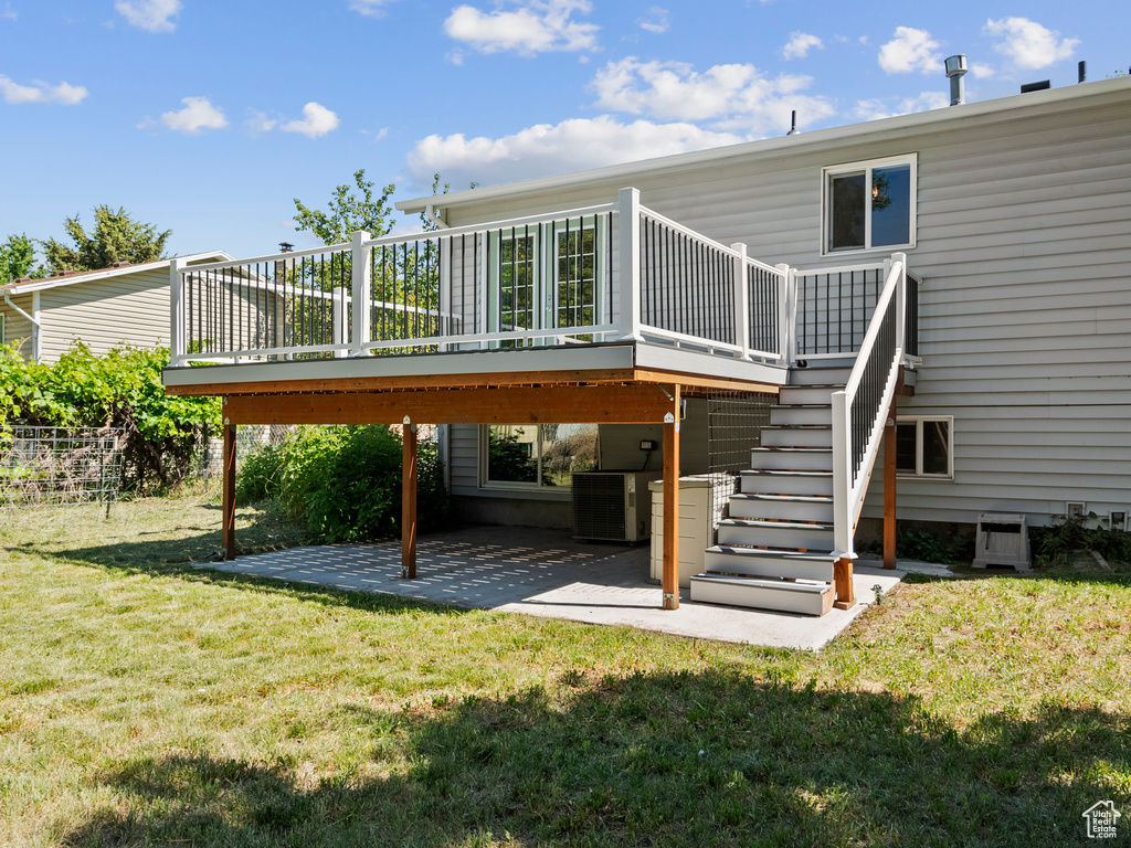 Rear view of property featuring a patio, a deck, a yard, and central AC