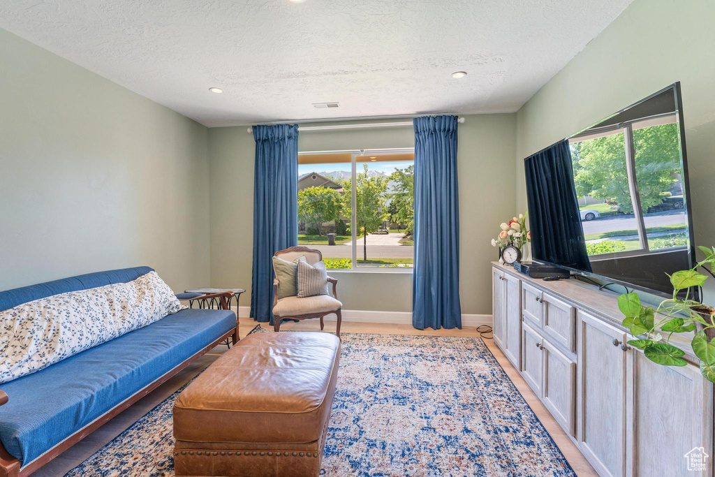 Living area featuring a textured ceiling, recessed lighting, and baseboards
