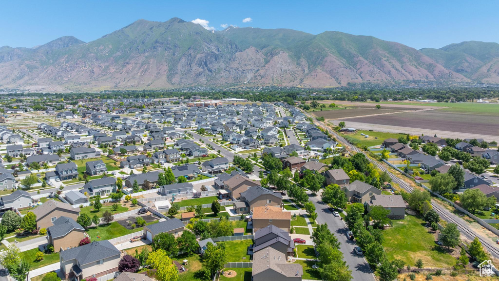 Aerial view of property and surrounding area with nearby suburban area and a mountainous background