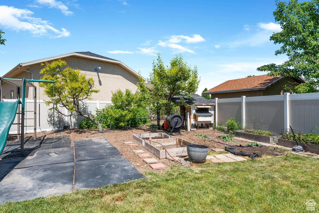View of yard featuring a vegetable garden and a patio