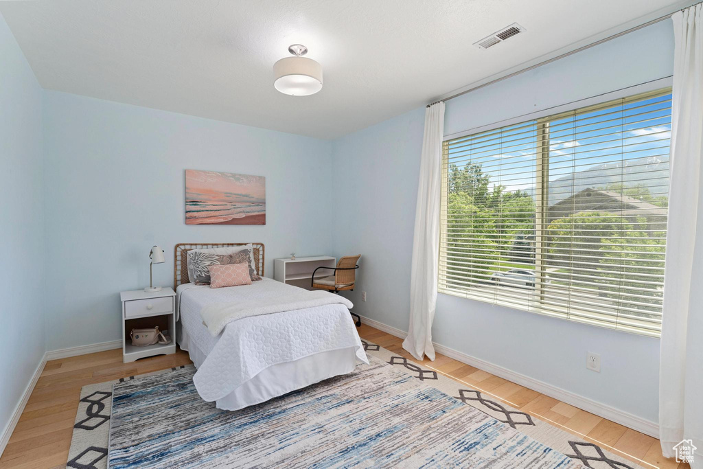 Bedroom with wood finished floors and baseboards