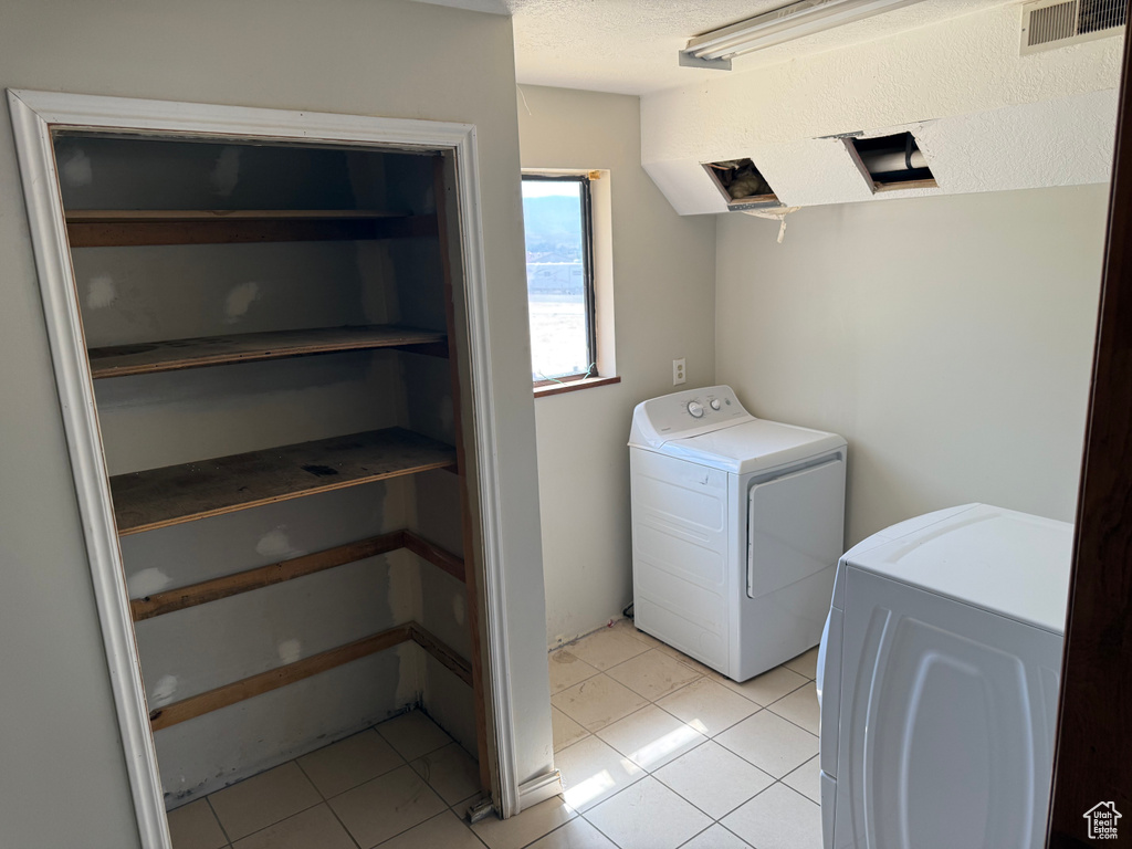 Laundry area with light tile patterned floors