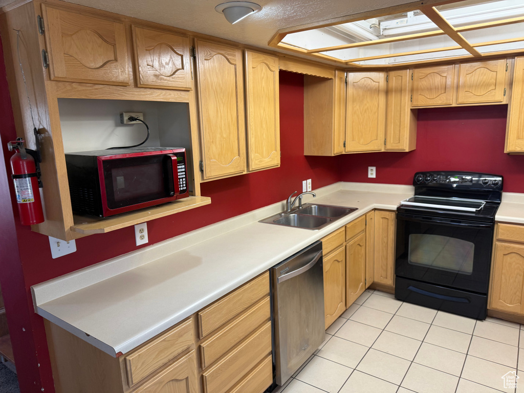Kitchen featuring black electric range, stainless steel dishwasher, light countertops, and light tile patterned flooring