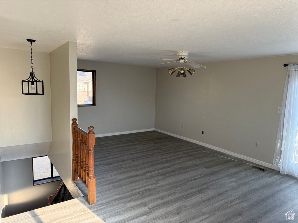Empty room with wood finished floors, ceiling fan, and healthy amount of natural light