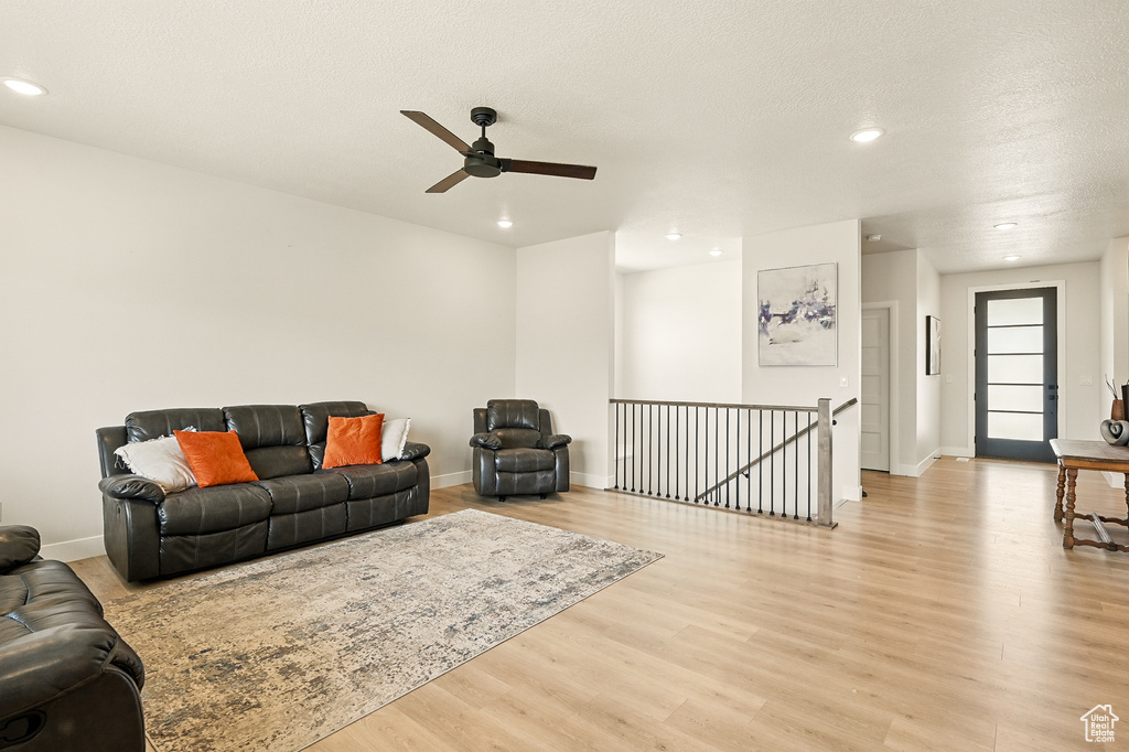 Living room featuring light wood-style floors, recessed lighting, ceiling fan, and baseboards
