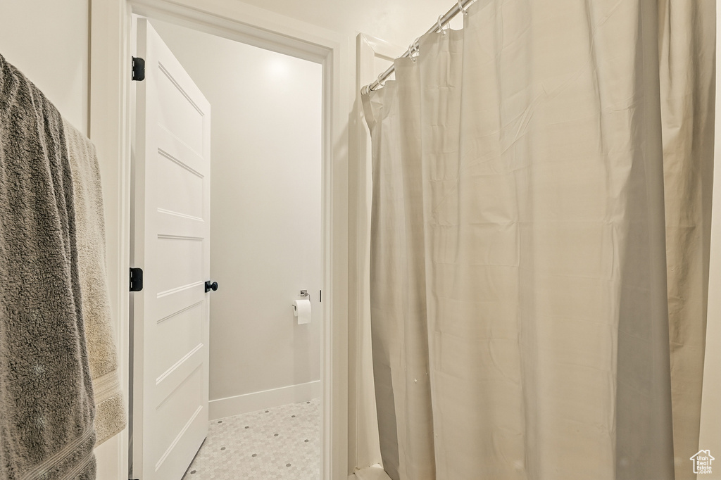 Full bathroom with baseboards and a shower with curtain