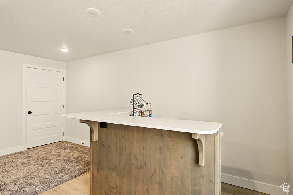 Indoor dry bar featuring light wood-style floors, baseboards, and recessed lighting
