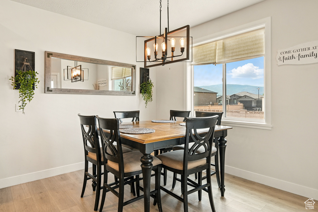 Dining room featuring a chandelier, light wood finished floors, and baseboards