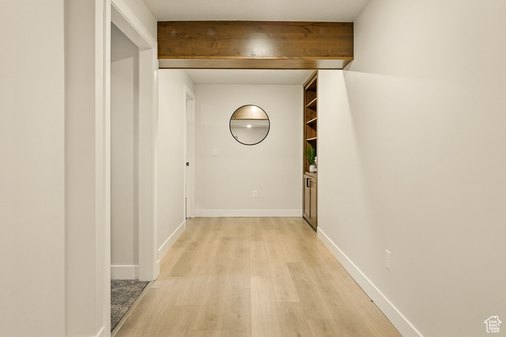 Hall with light wood-style flooring and baseboards