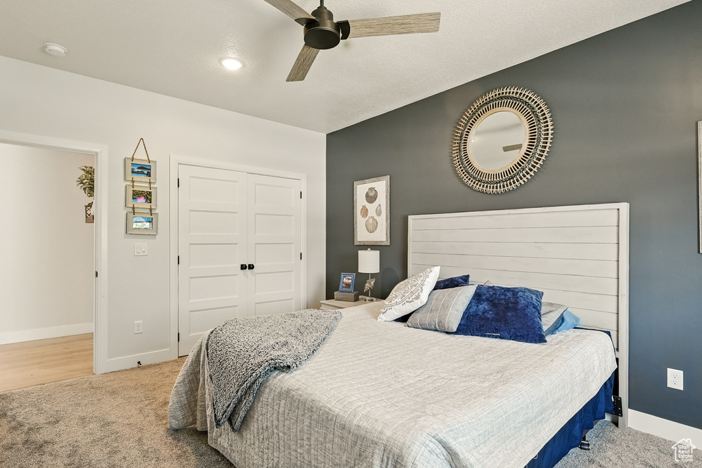 Carpeted bedroom featuring a closet, baseboards, and a ceiling fan