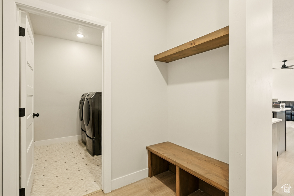 Washroom with washing machine and clothes dryer, baseboards, ceiling fan, and light wood-style floors