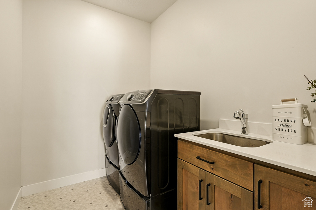 Laundry room with washing machine and clothes dryer, baseboards, and cabinet space