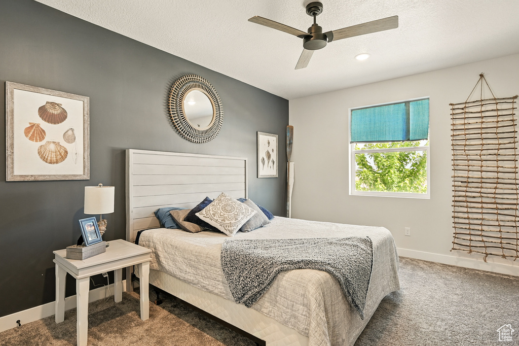 Carpeted bedroom featuring baseboards and a ceiling fan