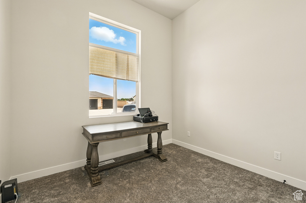 Home office featuring carpet and baseboards