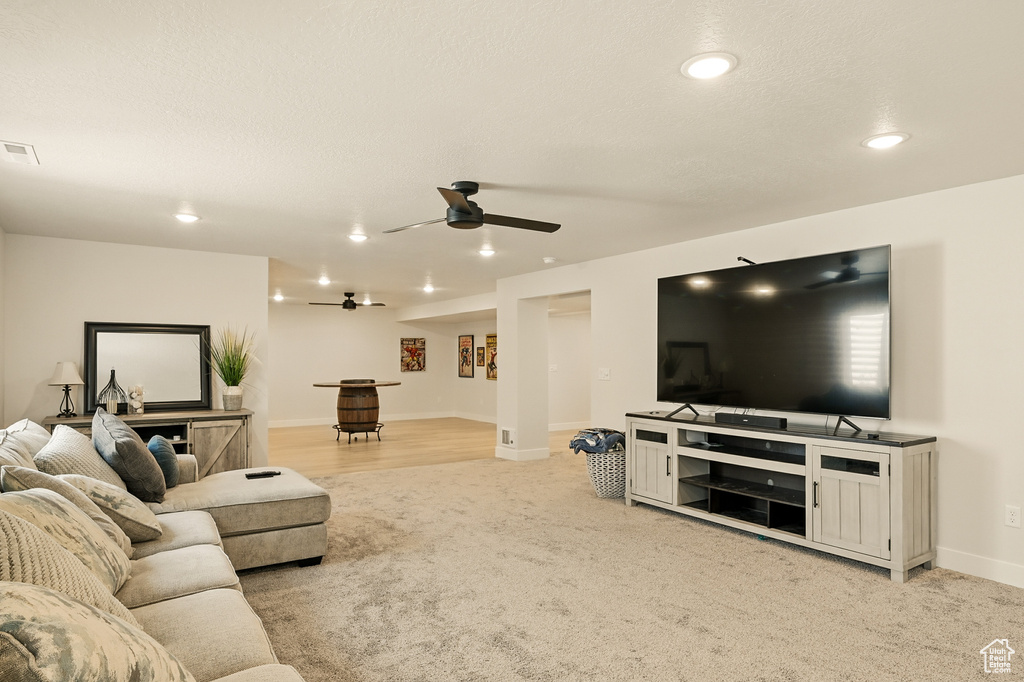 Living room with a ceiling fan, light colored carpet, recessed lighting, and baseboards