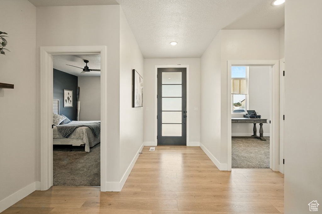 Foyer featuring light wood-style flooring, ceiling fan, a textured ceiling, baseboards, and recessed lighting