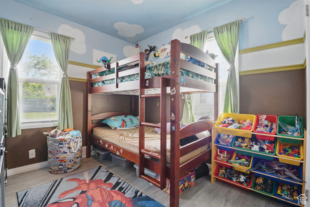 Bedroom featuring multiple windows, wood finished floors, and baseboards