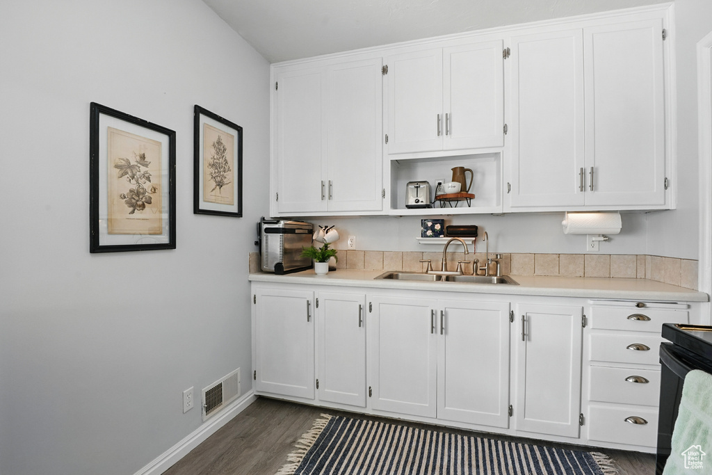 Kitchen featuring a sink, white cabinetry, and light countertops
