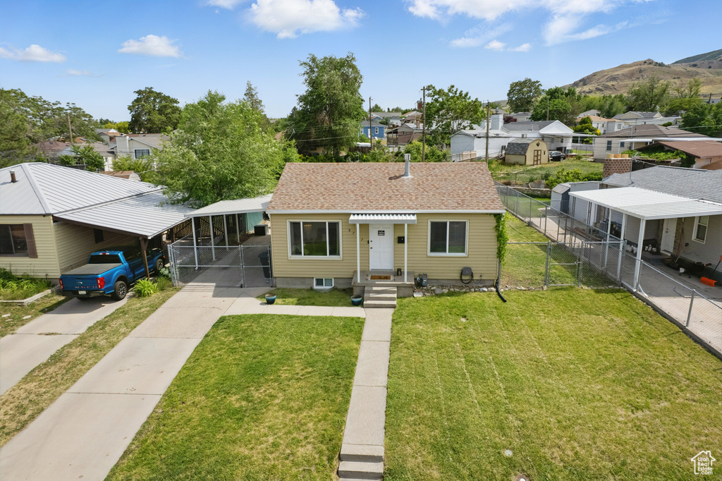 Bungalow-style house featuring a residential view, concrete driveway, a mountain view, and a carport