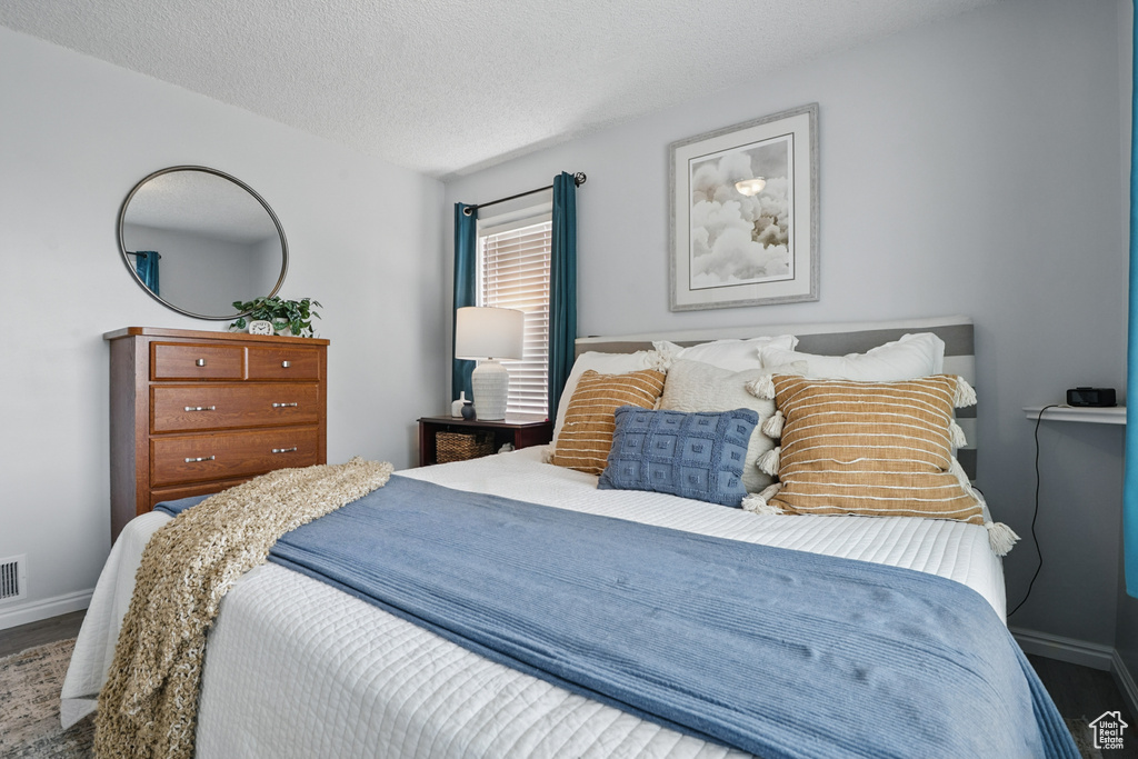 Bedroom with baseboards and a textured ceiling