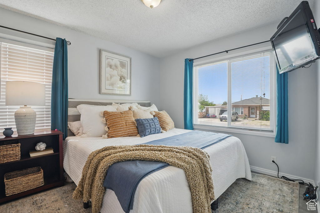 Bedroom with a textured ceiling and baseboards