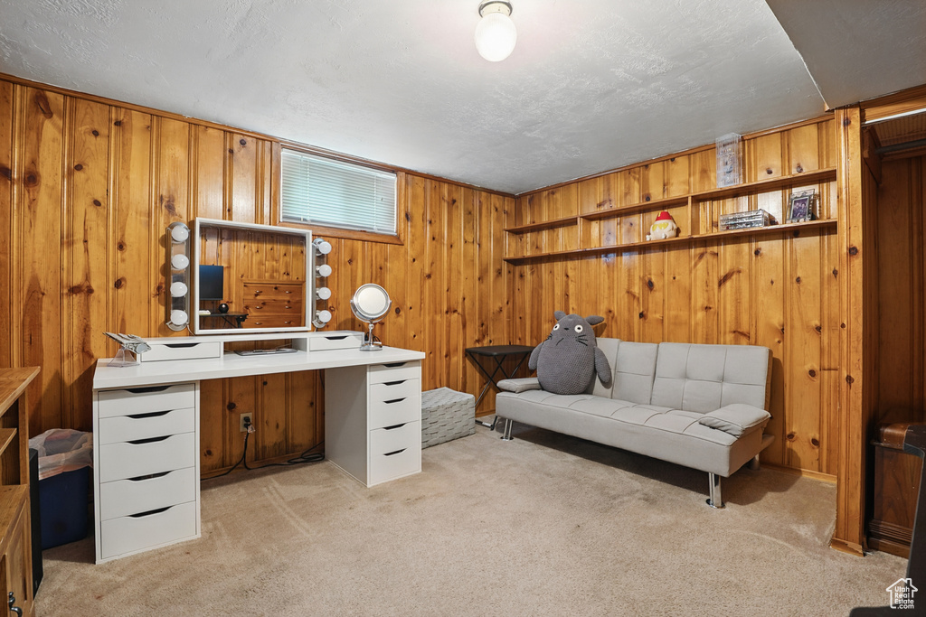 Home office featuring light colored carpet and wood walls