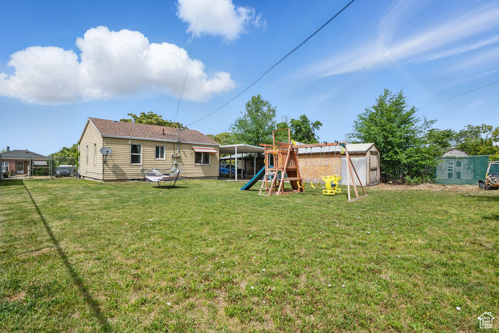 Rear view of house with a playground and a yard