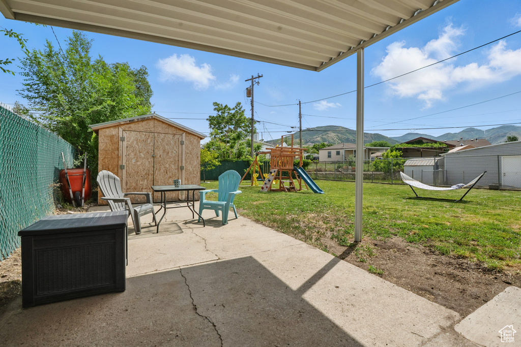 View of patio with a playground and a mountain view