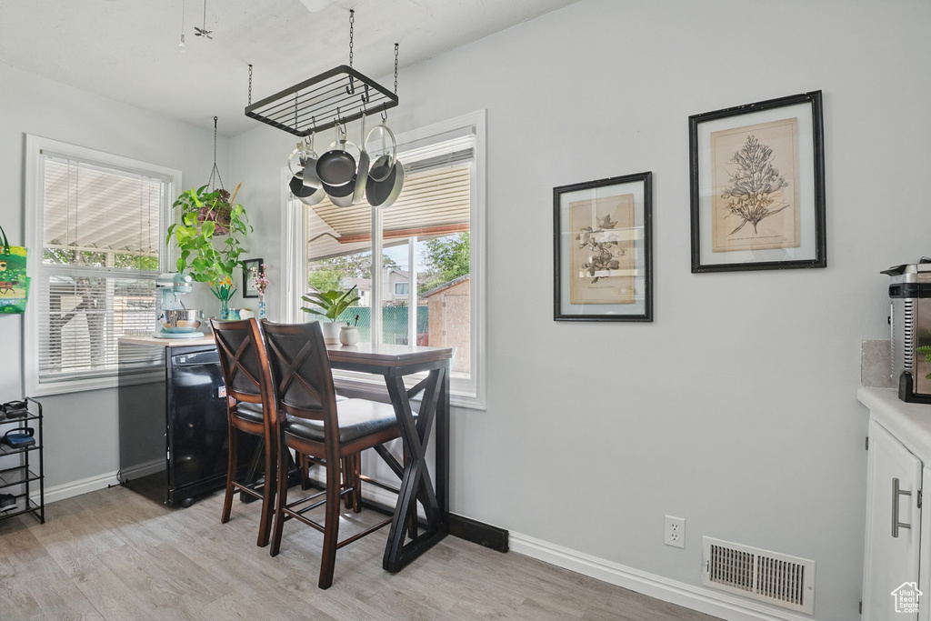 Dining space with light wood-type flooring, healthy amount of natural light, and baseboards