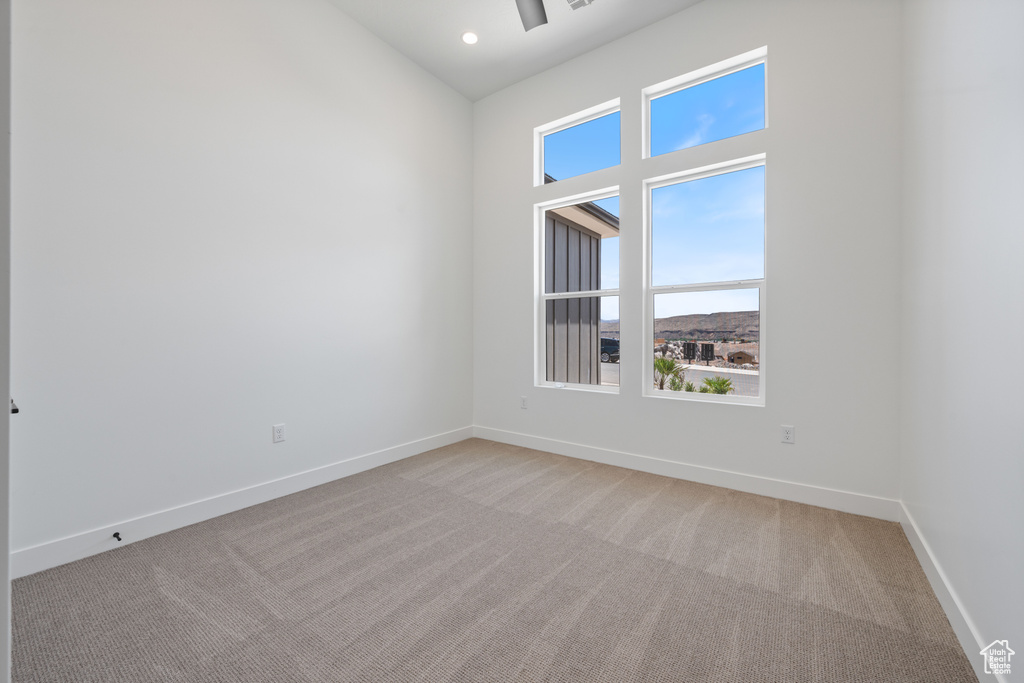 Empty room with light colored carpet, baseboards, ceiling fan, and recessed lighting