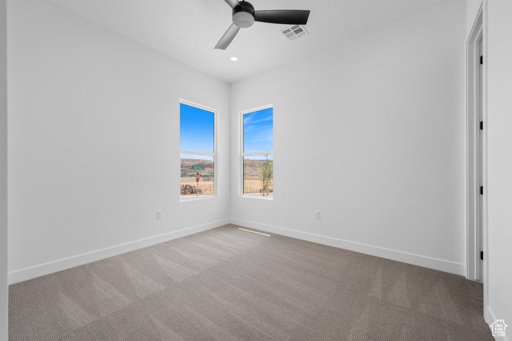 Carpeted empty room featuring ceiling fan, baseboards, and recessed lighting