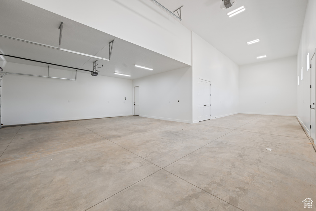 Garage featuring a garage door opener and baseboards